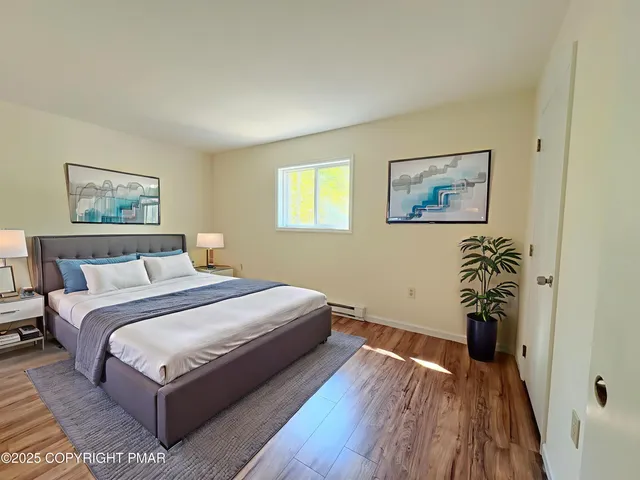 a bedroom with a bed and a painting on the wall