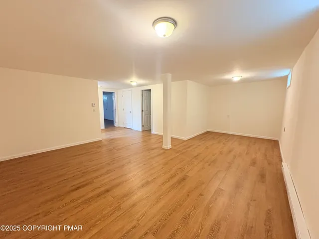a view of a room has wooden floor and a window