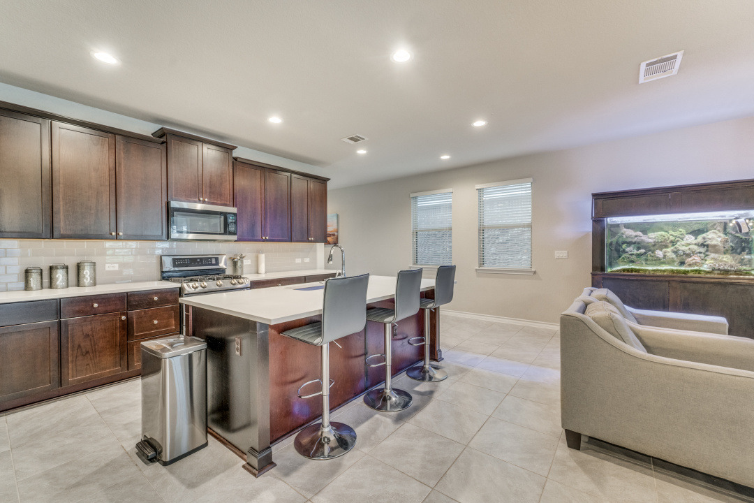 5921 Lehman Way Austin, TX 78747 - Photo 10 of 25 An inviting open-concept kitchen and living area features rich cabinetry and an expansive island with bar seating.