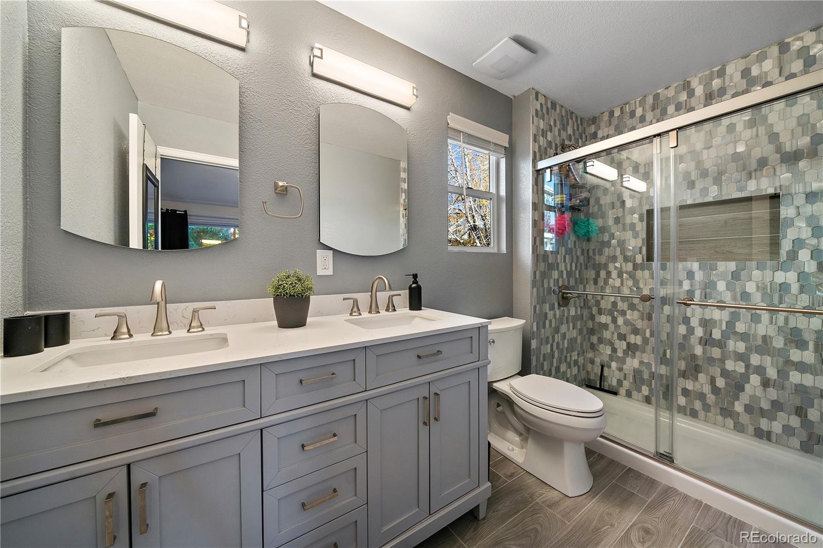 11312 Jersey Drive Thornton, CO 80233 - Photo 12 of 19 a bathroom with a double vanity sink toilet mirror and shower