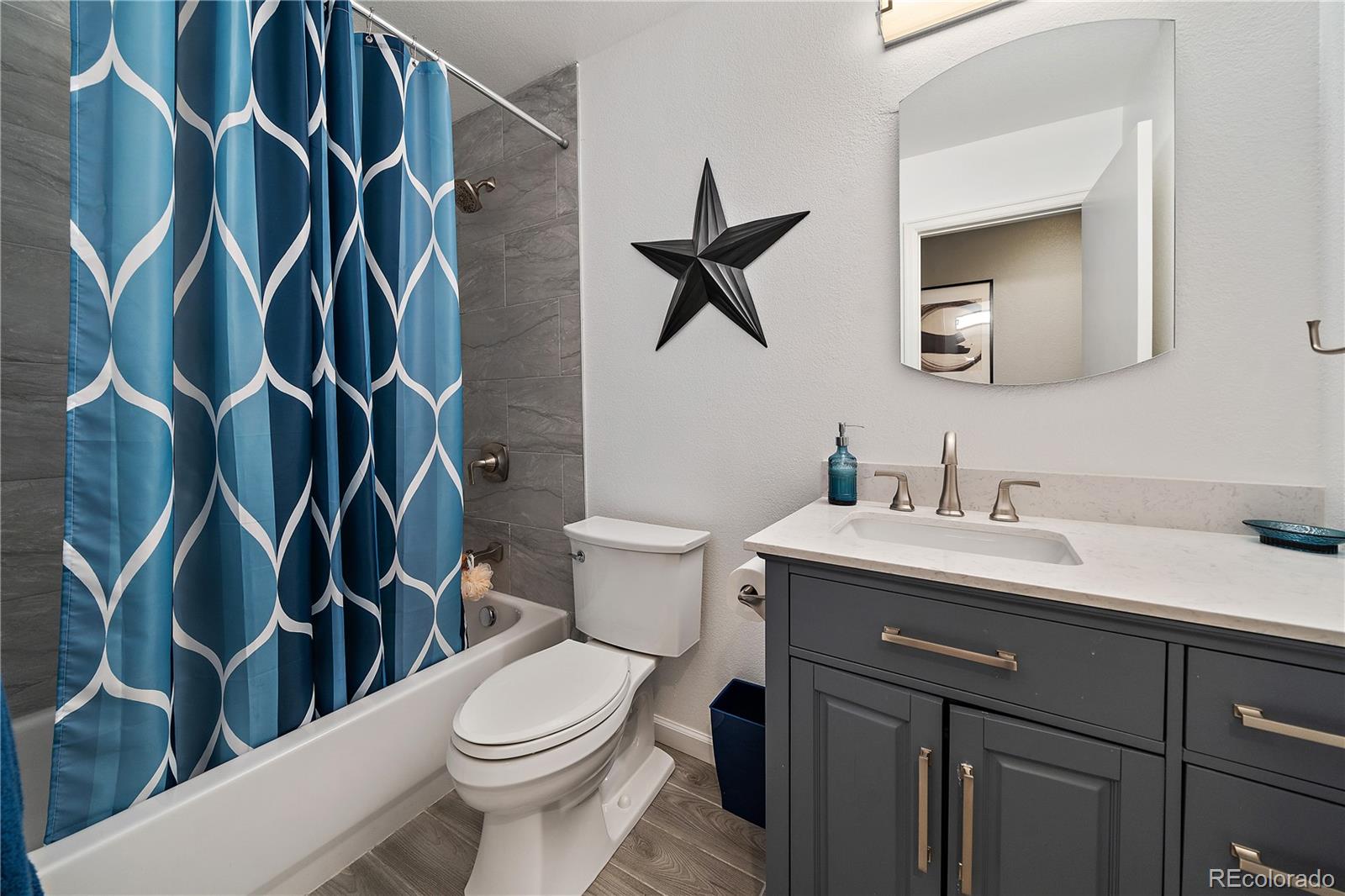 11312 Jersey Drive Thornton, CO 80233 - Photo 14 of 19 a bathroom with a granite countertop sink a toilet and a mirror