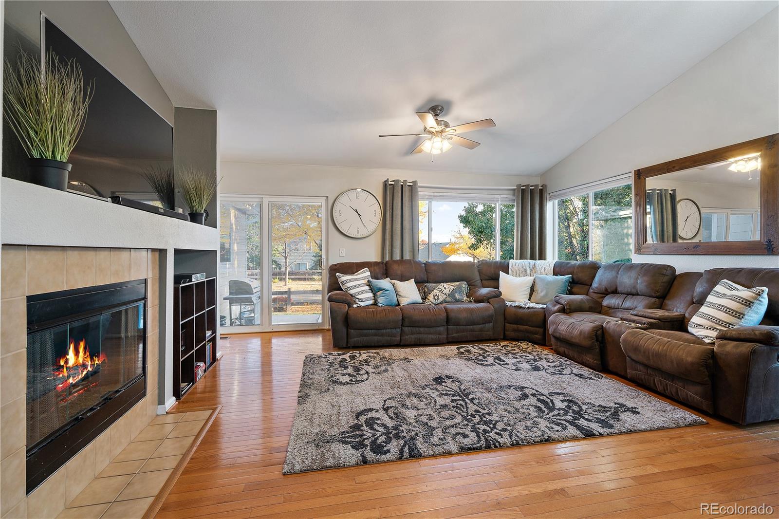 11312 Jersey Drive Thornton, CO 80233 - Photo 4 of 19 a living room with furniture a flat screen tv and a fireplace
