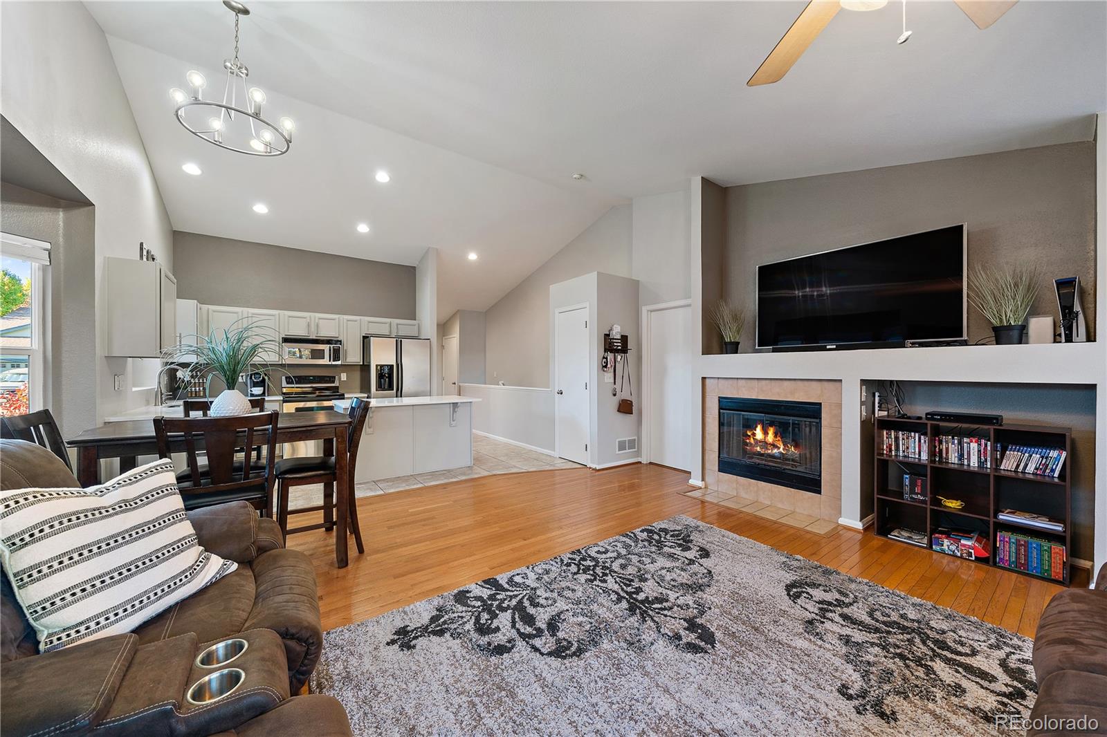 11312 Jersey Drive Thornton, CO 80233 - Photo 5 of 19 a living room with furniture a flat screen tv and a fireplace