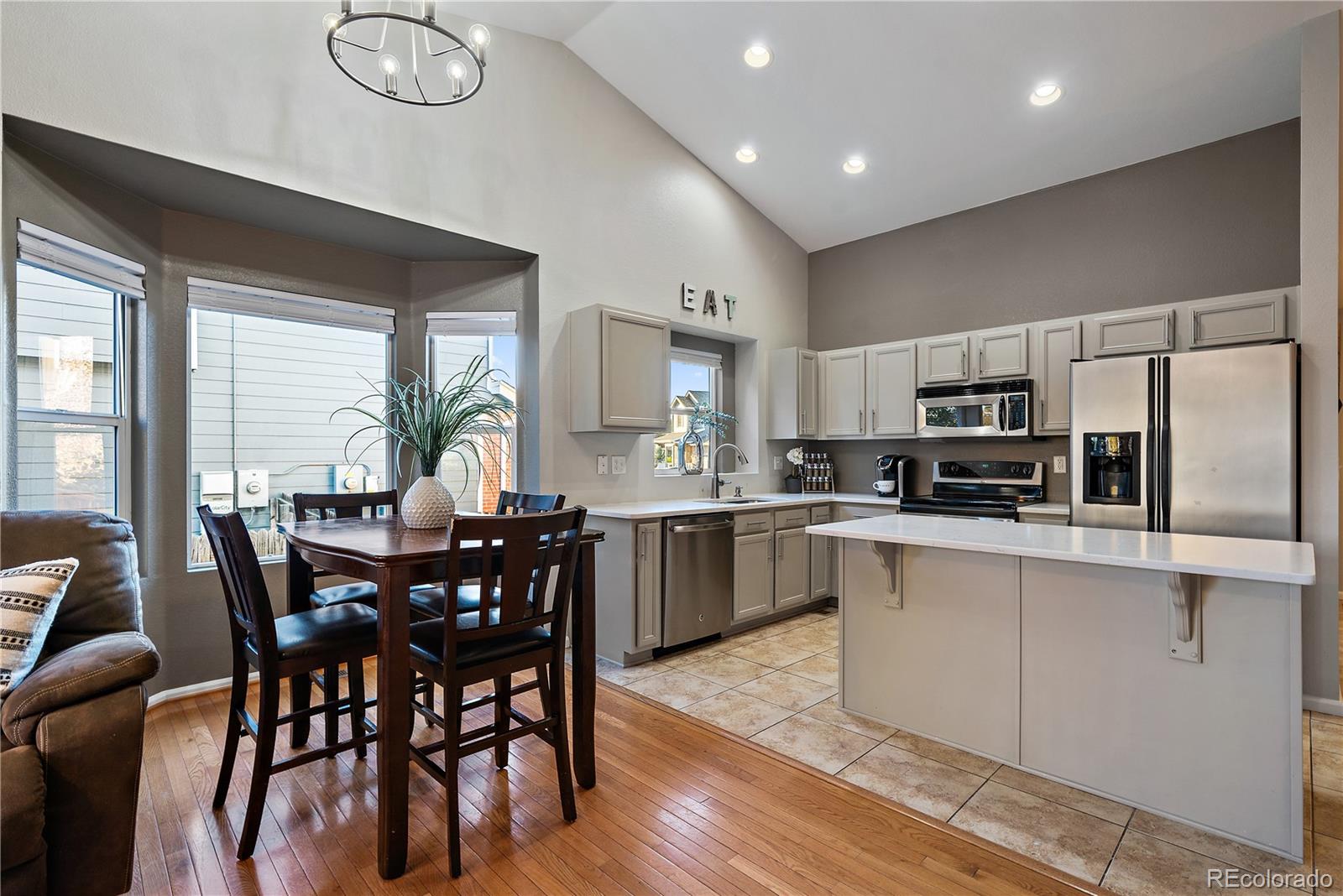 11312 Jersey Drive Thornton, CO 80233 - Photo 6 of 19 a kitchen with stainless steel appliances granite countertop a stove top oven a sink a dining table and chairs