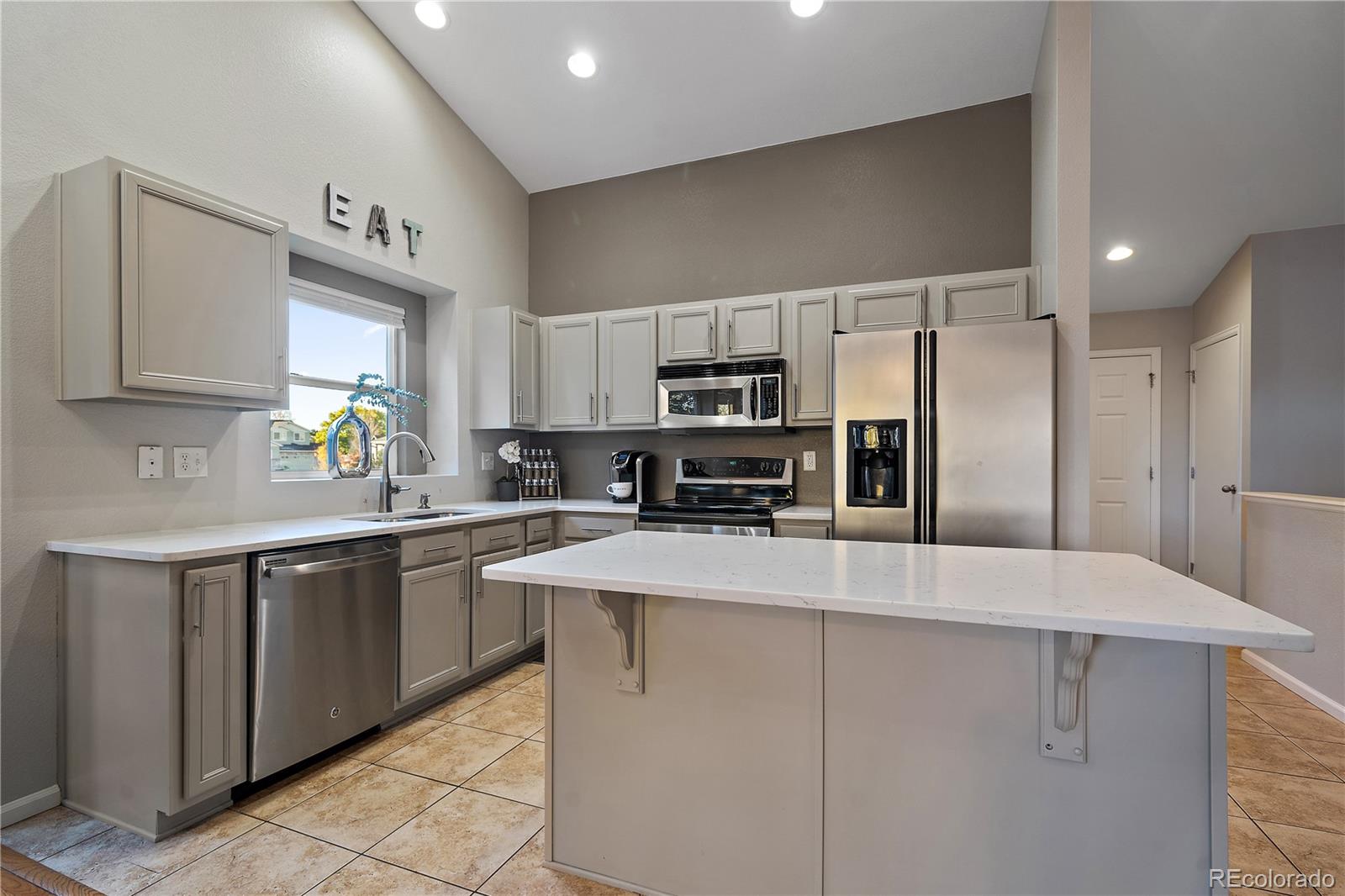 11312 Jersey Drive Thornton, CO 80233 - Photo 7 of 19 a kitchen with kitchen island a counter top space appliances and a sink