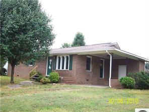 a view of a yard in front of a house with large windows