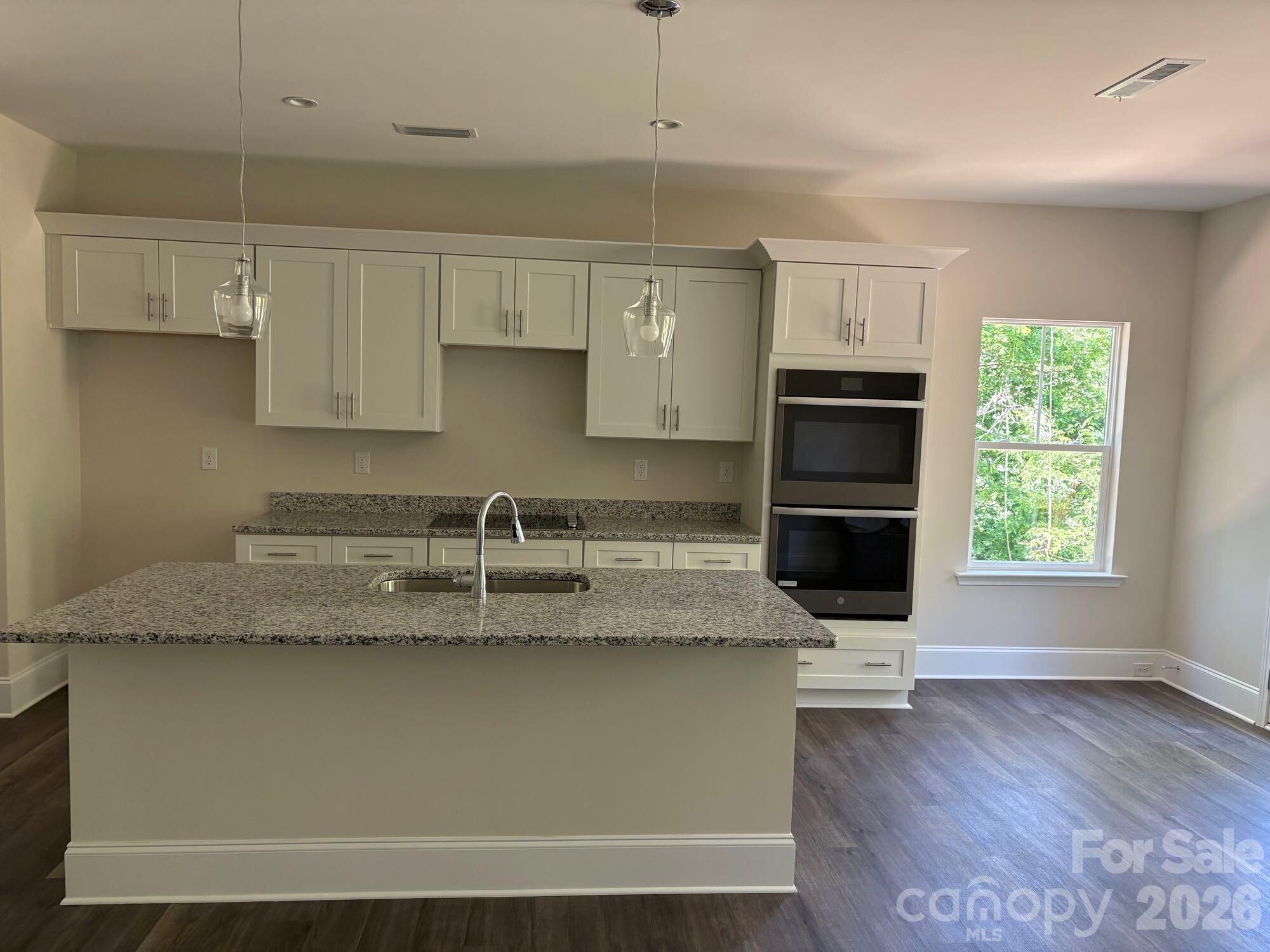 250 Ashley Acres Road Statesville, NC 28677 - Photo 7 of 21 a kitchen with kitchen island granite countertop a sink cabinets and stainless steel appliances