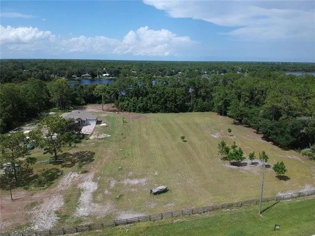 an aerial view of residential houses with outdoor space and trees