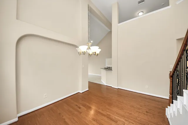 a view of a room with wooden floor and a ceiling fan
