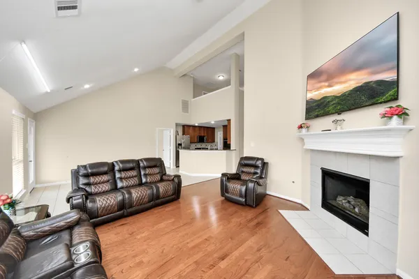 a living room with furniture a flat screen tv and a fireplace