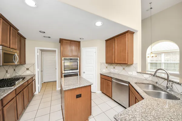 a kitchen with stainless steel appliances granite countertop a sink stove and refrigerator