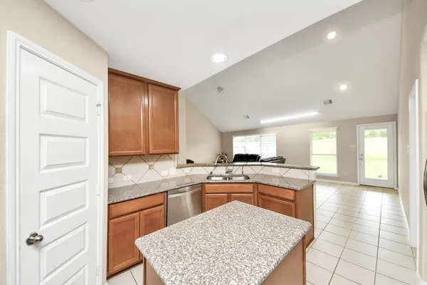 a kitchen with a stove a sink dishwasher a refrigerator and cabinets with wooden floor