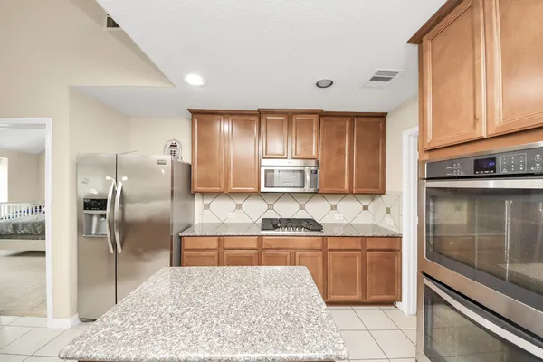 a kitchen with stainless steel appliances granite countertop a sink stove and refrigerator
