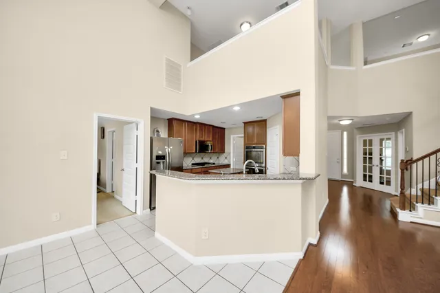 a view of a kitchen with kitchen island granite countertop a refrigerator and a stove top oven