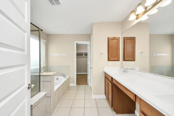 a spacious bathroom with a bathtub sink and mirror