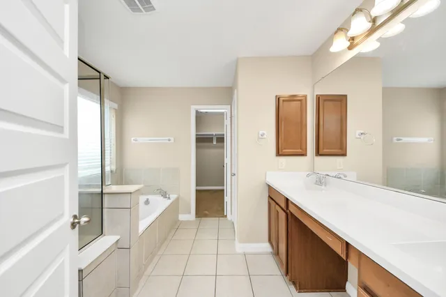 a spacious bathroom with a bathtub sink and mirror