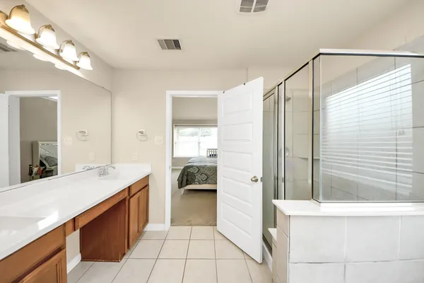 a bathroom with a granite countertop sink a mirror and shower