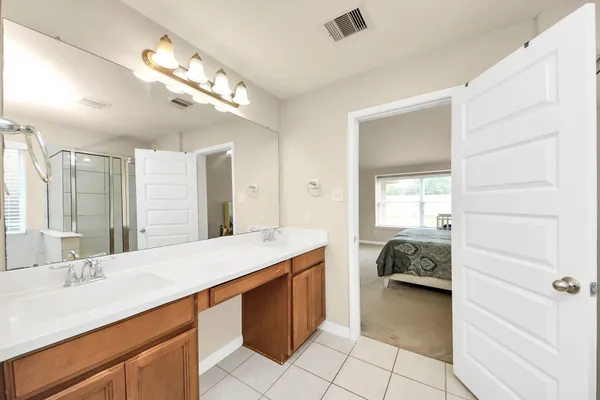 a en suite bathroom with a sink double vanity and a mirror