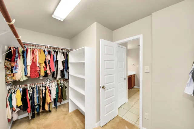 a view of walk in closet with clothes and shoes