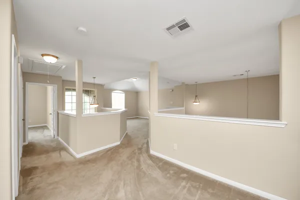 a view of a big room with wooden floor and windows