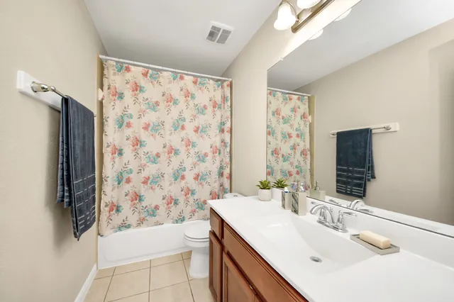 a bathroom with a sink a toilet and shower curtain