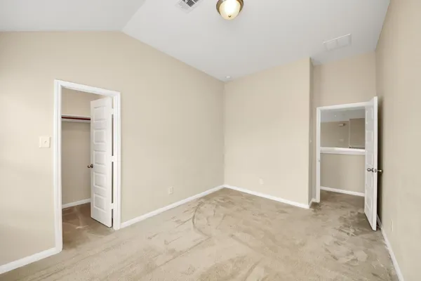 an empty room with closet and windows