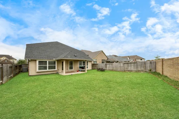 a view of a house with a big yard and large trees