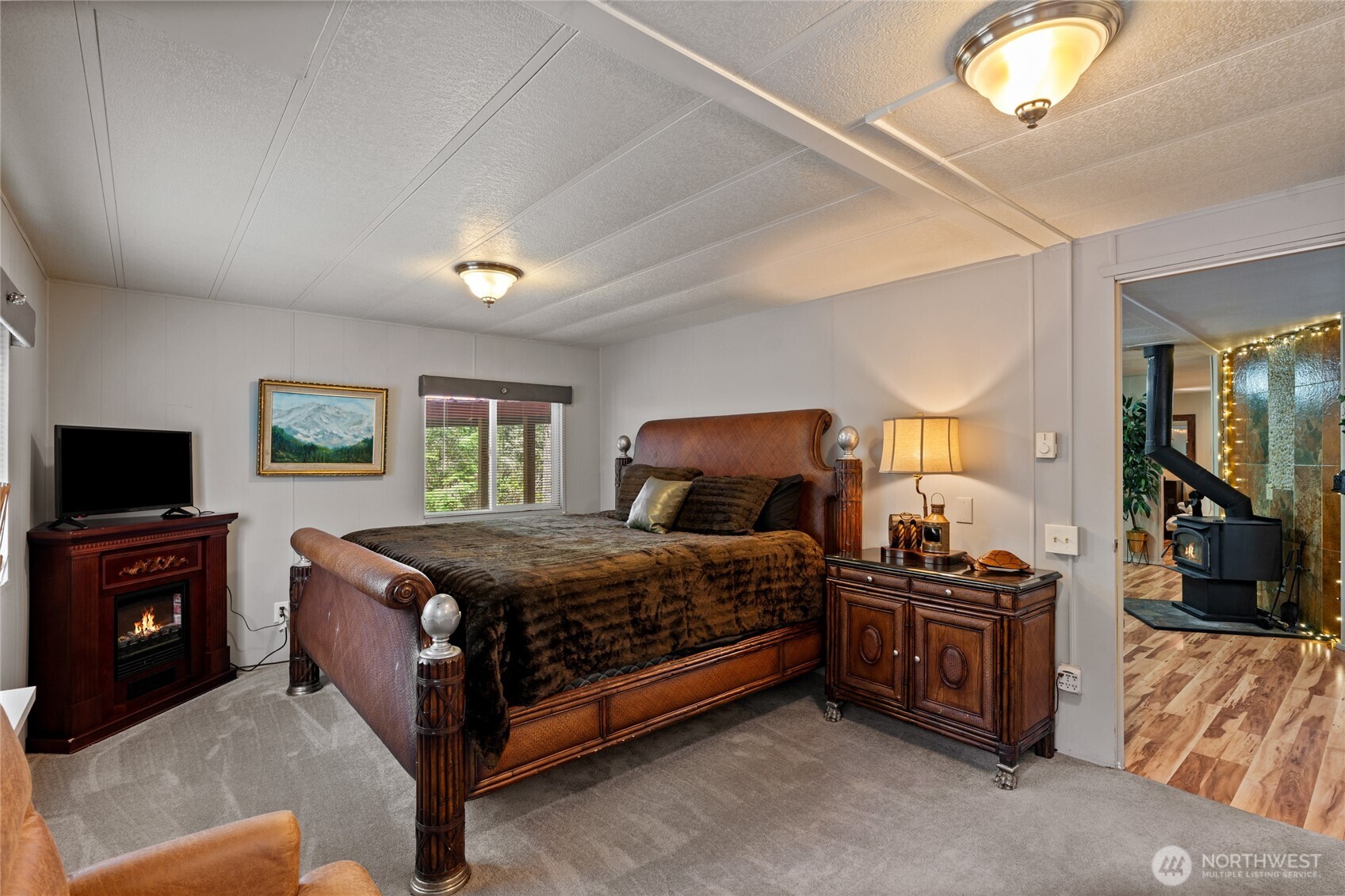 271 Skate Creek Road North Ashford, WA 98304 - Photo 11 of 40 a bedroom with a bed and a flat tv screen on dresser