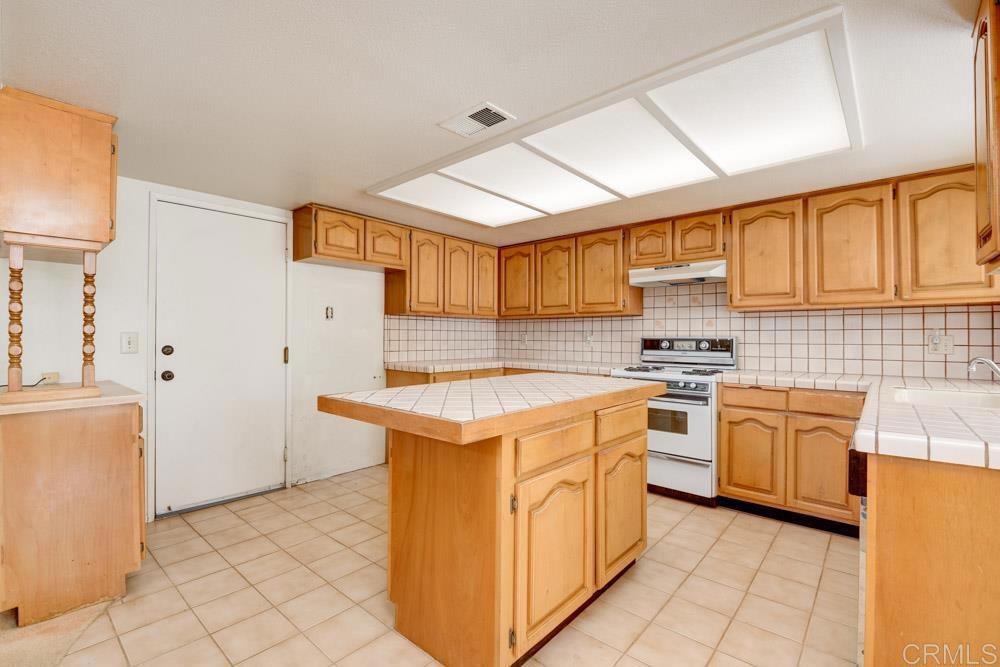 1706 Catalpa Road Carlsbad, CA 92011 - Photo 11 of 30 a kitchen with stainless steel appliances granite countertop a stove a sink and a refrigerator