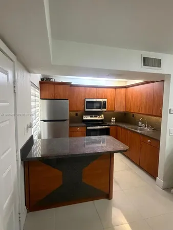 a kitchen with stainless steel appliances granite countertop a sink a stove and a refrigerator