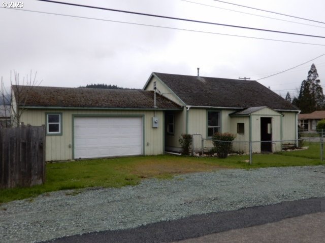 411 East 3rd Avenue Riddle, OR 97469 - Photo 1 of 21 a front view of a house with a garden and trees