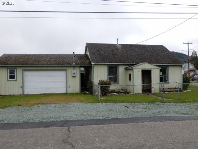411 East 3rd Avenue Riddle, OR 97469 - Photo 21 of 21 a front view of a house with a garden and trees