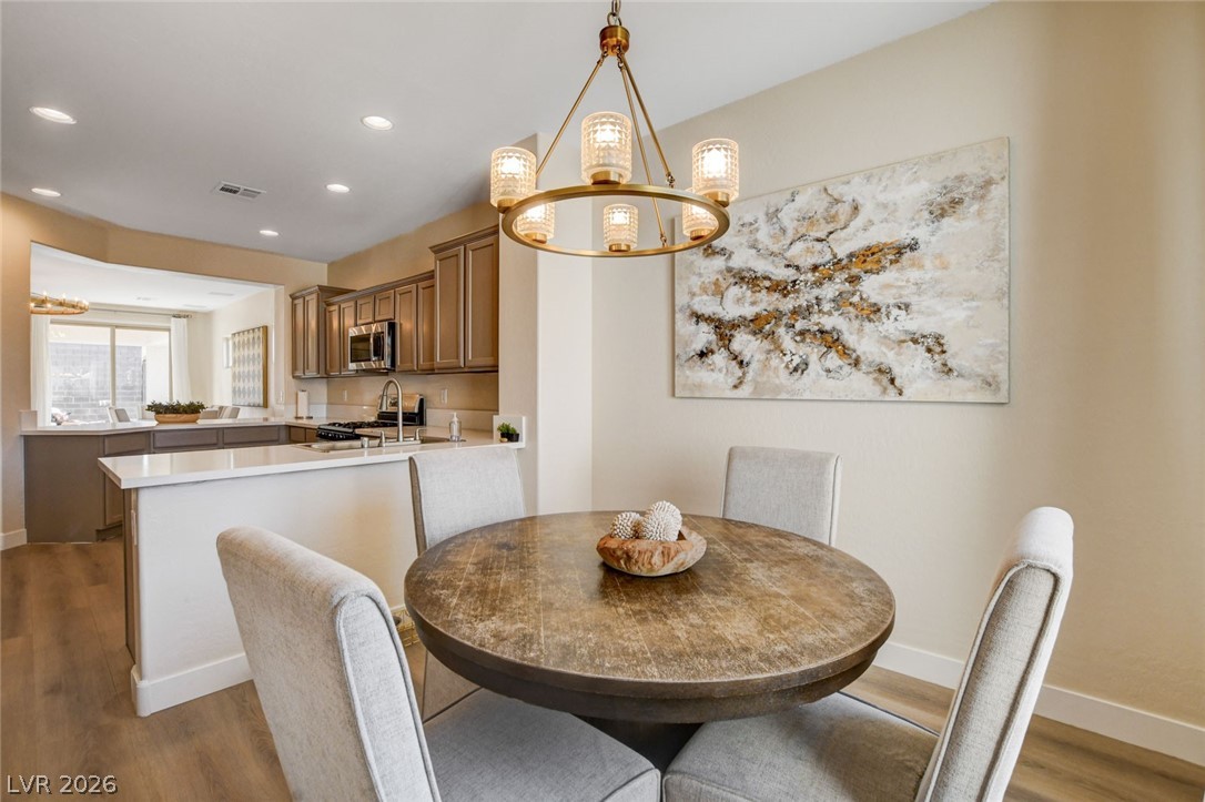 2649 Rue Marquette Avenue Henderson, NV 89044 - Photo 28 of 55 This inviting dining area features a robust round table and an elegant circular chandelier.