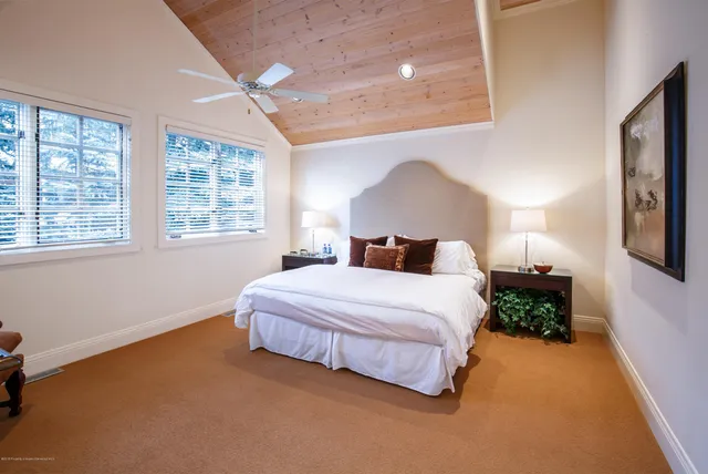 a bedroom with a bed lamp and a large window