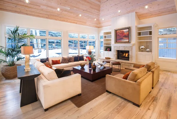 a living room with furniture fireplace and a large window