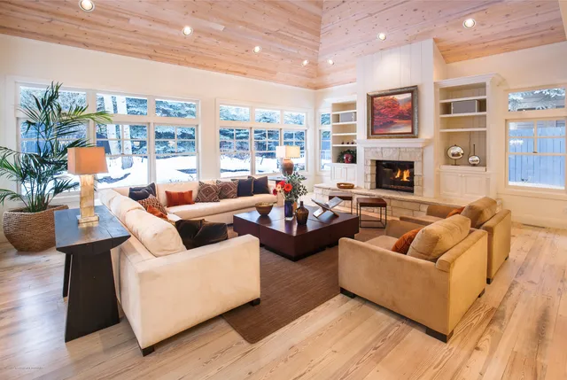 a living room with furniture fireplace and a large window