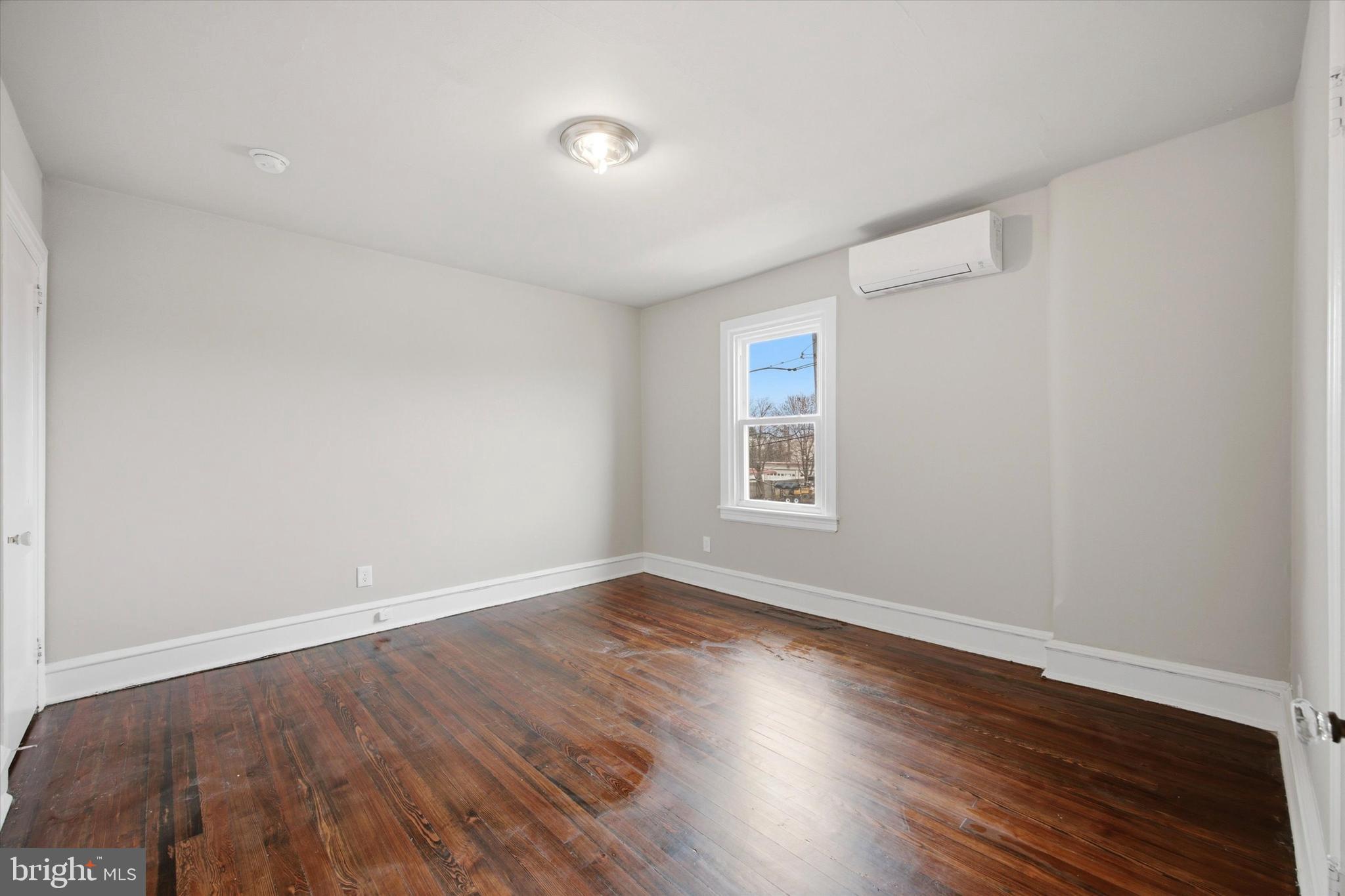 101 North Eagle Road, Unit 2 Havertown, PA 19083 - Photo 5 of 8 an empty room with wooden floor and windows