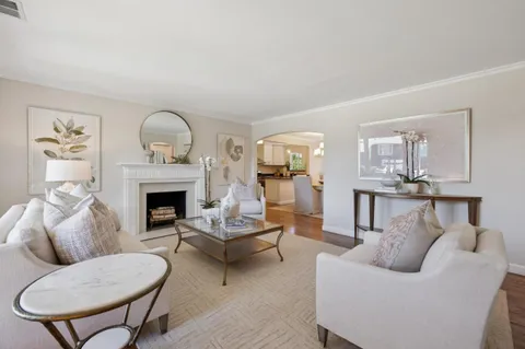 a living room with furniture a fireplace and a chandelier