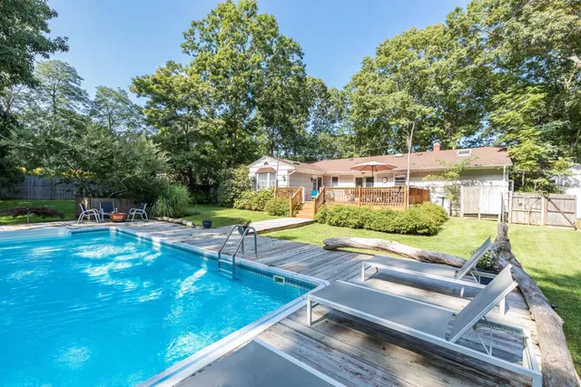 a view of a house with backyard and sitting area