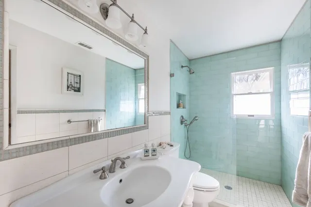 a bathroom with a sink a toilet and shower