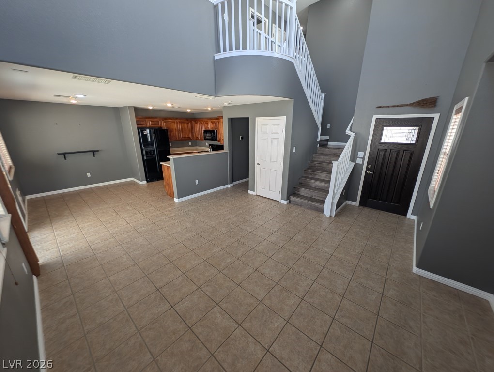 9121 Spoonbill Ridge Place Las Vegas, NV 89143 - Photo 3 of 26 A grand entrance with a sweeping staircase and adjacent kitchen area, perfect for entertaining.