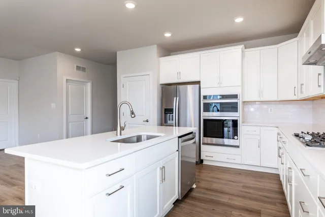 a kitchen with stainless steel appliances a refrigerator sink and cabinets