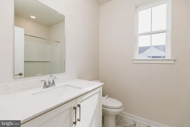a bathroom with a sink a toilet and a mirror