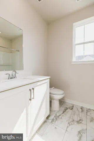a bathroom with a sink toilet and window