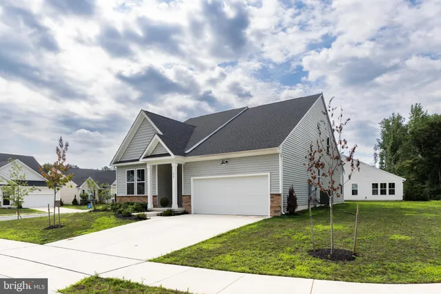 a aerial view of a house next to a big yard and large trees