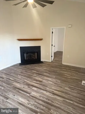 a view of a livingroom with wooden floor and a fireplace