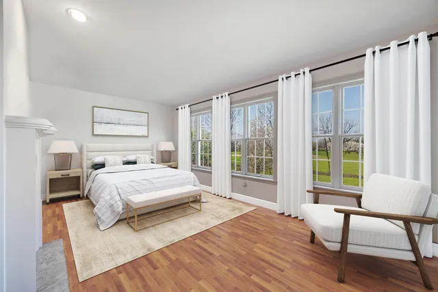 a spacious bedroom with a bed a couch and a window