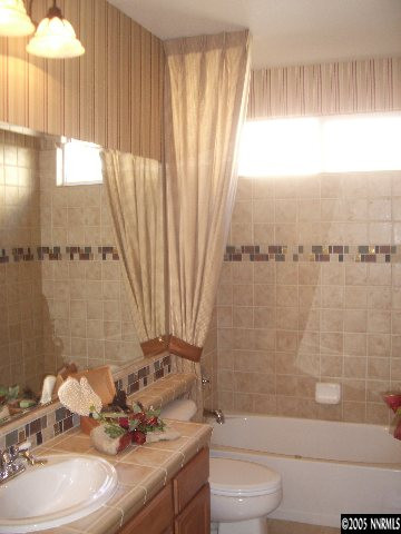 10631 Fort Morgan Way, Unit 1 Reno, NV 89521 - Photo 3 of 6 a bathroom with a sink a toilet and tub