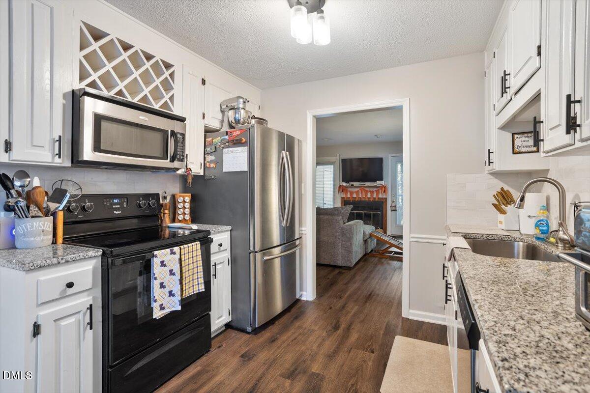 5442 Sharpe Drive Raleigh, NC 27612 - Photo 5 of 20 a kitchen with stainless steel appliances granite countertop a refrigerator stove and sink