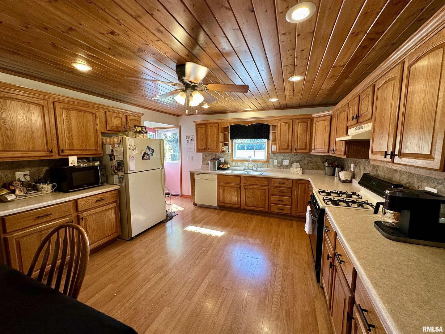 878 County Road 600N Sims, IL 62886 - Photo 41 of 82 a kitchen with stainless steel appliances kitchen island granite countertop a stove top oven a sink dishwasher a dining table and chairs with wooden floor
